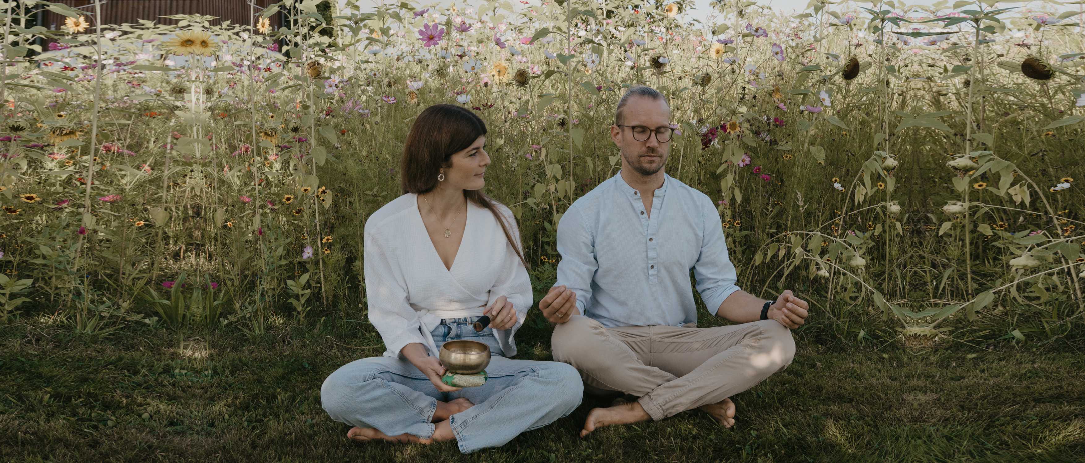 Wolfgang und Lisa meditieren in einer Blumenwiese